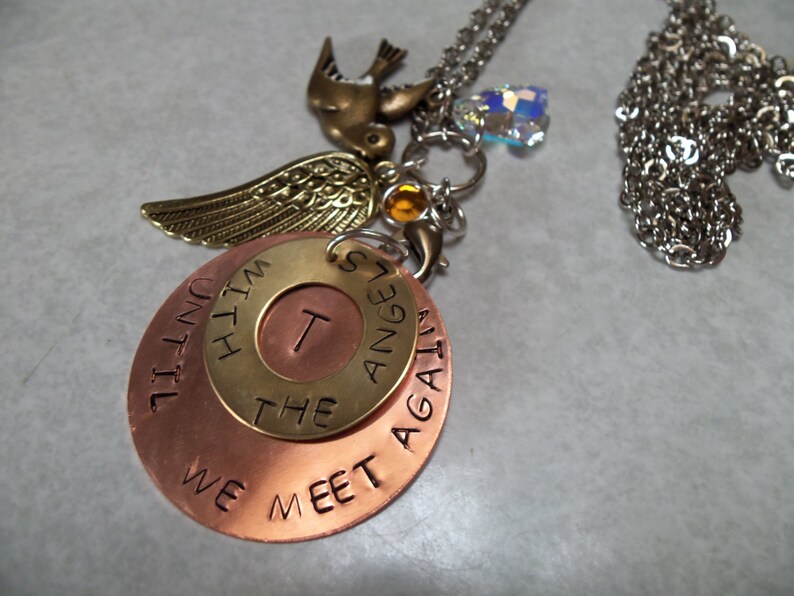 May include: A silver chain necklace with a copper pendant that reads "Until We Meet Again" with a smaller brass circle pendant that reads "The Angels" and a small bird charm.