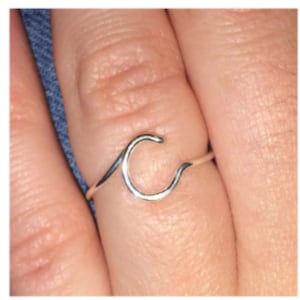 May include: A silver ring with a wave-shaped letter C design.