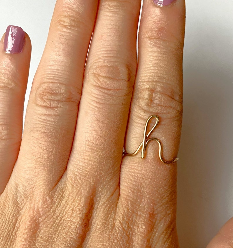 script letter ring in gold or silver cursive font.