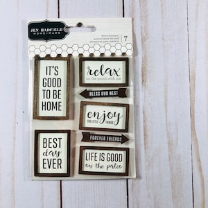 May include: A sheet of seven wood stickers with various sayings. The stickers are brown with white lettering. The sayings include "It's good to be home", "Relax on the porch with me", "Bless our nest", "Enjoy the little things", "Forever friends", "Best day ever", and "Life is good on the patio".