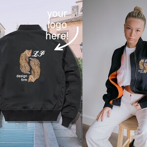 May include: Black bomber jacket with an embroidered design of two leopards and the text "LP design firm" on the back.