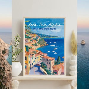 Könnte beinhalten: Ein rechteckiger gerahmter Kunstdruck mit einem Küstenlandschaftsgemälde, das Gebäude, eine Straße und Boote auf dem Wasser zeigt. Der Text Zeta Tau Alpha und WISH YOU WERE HERE! ist in Weiß oben auf der farbenfrohen, illustrativen Szene gedruckt.