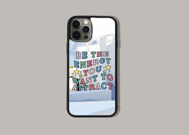 May include: A black phone case with a white background and the text "BE THE ENERGY YOU WANT TO ATTRACT" in colourful letters with yellow stars.