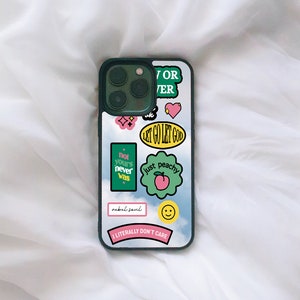 May include: A black phone case with a variety of colourful stickers. The stickers include phrases like "Let Go Let God", "Not Yours Never Was", "Just Peachy", and "I Literally Don't Care".