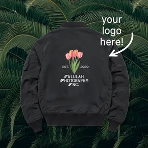 May include: Black bomber jacket with a white logo that says "ALULAH PHOTOGRAPHY NC" and "EST. 2020". The logo is surrounded by a floral design with pink and orange tulips.