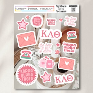 May include: A set of pink and white stickers with various designs, including stars, hearts, envelopes, phones, and mugs. The stickers feature the text "Kappa Alpha Theta" and "KAO".