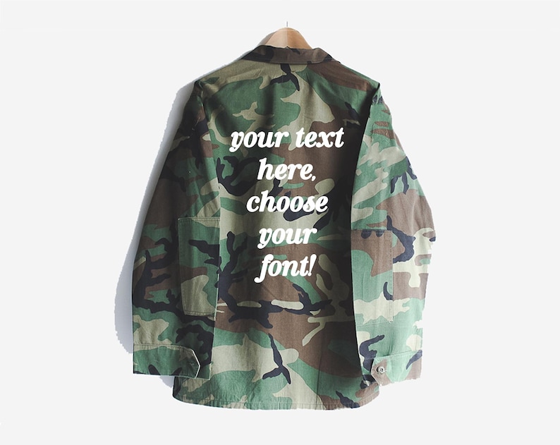 Puede incluir: Una chaqueta utilitaria de color verde camuflaje con un texto blanco superpuesto que dice "your text here, choose your font!"