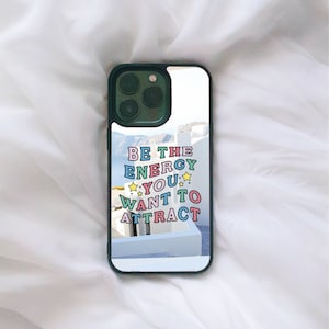 May include: A green phone case with a white background and the text "BE THE ENERGY YOU WANT TO ATTRACT" in colourful letters.