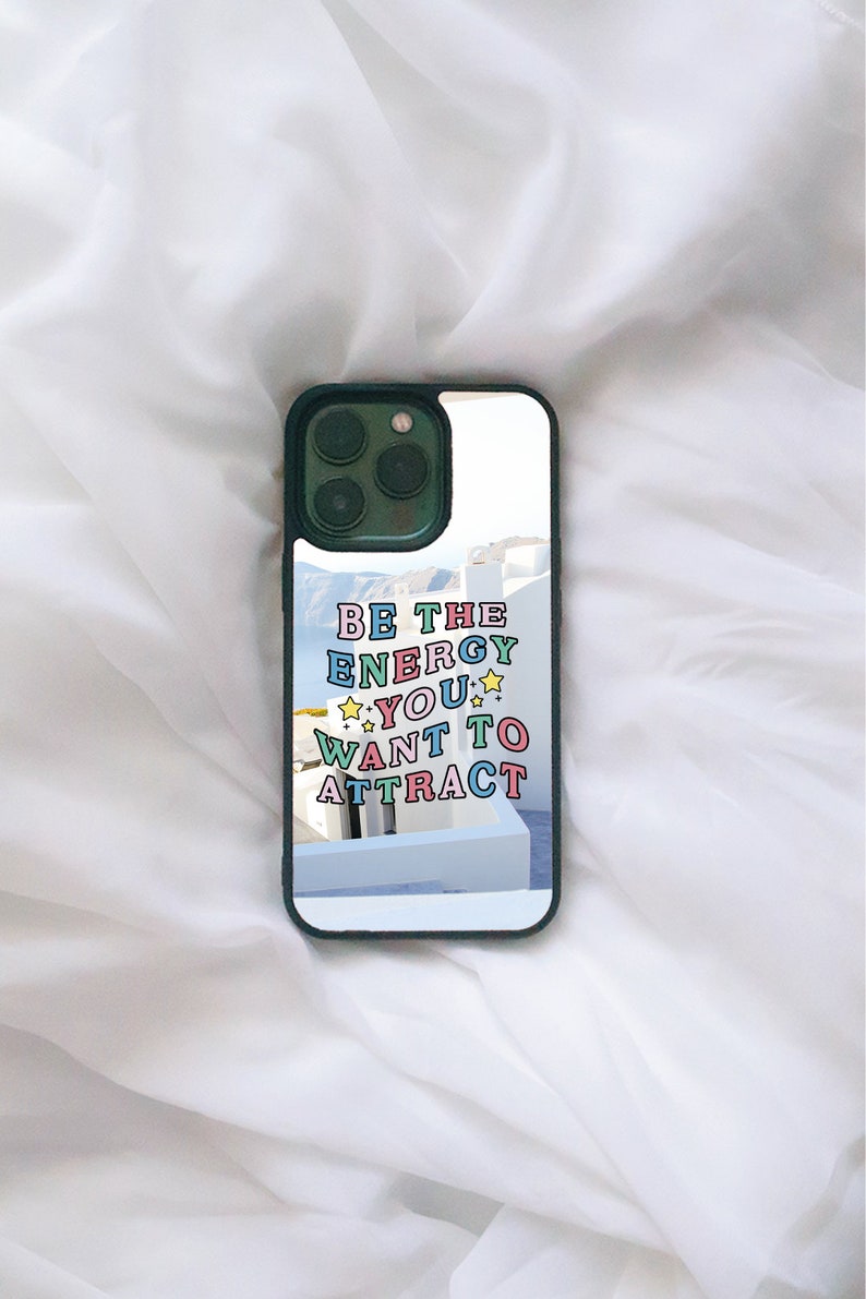 May include: A green phone case with a white background and the text "BE THE ENERGY YOU WANT TO ATTRACT" in colourful letters.