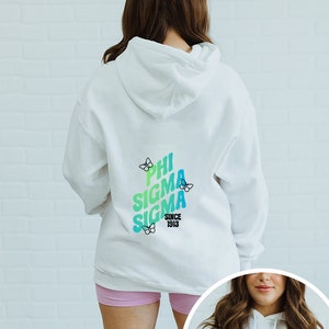 May include: White hooded sweatshirt with a colourful graphic on the back that says "Phi Sigma Sigma Since 1913" with butterflies around the text.