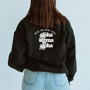 May include: Black sweatshirt with white text on the back that reads "Wish you were here alpha sigma alpha".