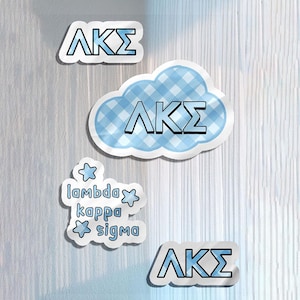 Könnte beinhalten: Eine Sammlung von vier Aufklebern mit den griechischen Buchstaben Lambda Kappa Sigma in Blau. Ein Aufkleber hat die Form einer blau-weiß karierten Wolke, zwei sind einfache Umrisse der Buchstaben und einer enthält den Text lambda kappa sigma mit Sternen.