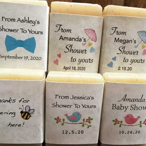 Pode incluir: Seis pequenas barras de sabonete branco com etiquetas impressas. As etiquetas t&ecirc;m diferentes designs e textos, incluindo "From Ashley's Shower To Yours", "From Amanda's Shower to yours", "From Megan's Shower to yours", "Thanks for bee-ing here!", "From Jessica's Shower To Yours", e "Amanda's Baby Shower".