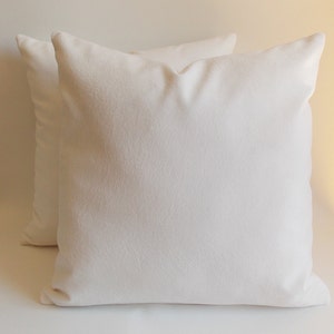 May include: Two white cotton pillow covers with a subtle textured surface.