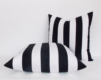 May include: Two black and white striped throw pillows. The pillows are made of a soft, comfortable fabric and have a simple, modern design.