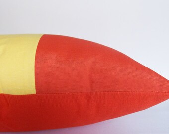 May include: A yellow and red rectangular pillow with a seam down the middle.