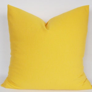 May include: A bright yellow throw pillow with a square shape and a soft, smooth texture.