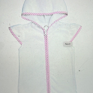 May include: White hooded towel with pink and white striped trim. The towel has a zipper down the front and a label that says "Next".
