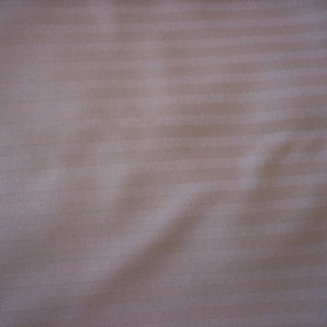 May include: White striped fabric with a smooth texture. The fabric is slightly wrinkled and has a subtle sheen.