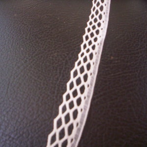 May include: White lace trim with a diamond pattern. The lace is delicate and has a soft texture.