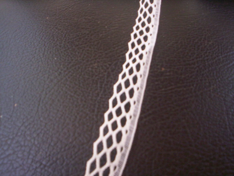 May include: White lace trim with a diamond pattern. The lace is delicate and has a soft texture.