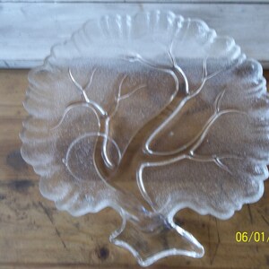 Puede incluir: Un plato de servir de vidrio transparente con forma de &aacute;rbol con un dise&ntilde;o esmerilado. El plato tiene una base ancha y un tronco de &aacute;rbol que se ramifica en un dise&ntilde;o de hojas.