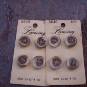 Può includere: Due carte di bottoni in plastica marrone con il testo "Lansing" e "60¢" stampato su di esse. Le carte sono etichettate con il numero "8640" e la taglia "24-1/2" 4 On."
