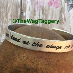 May include: Silver bracelet with the inscription "Sometimes we bend us the wings we have".