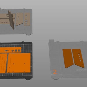 May include: An overhead view of 3D printer parts in various stages of assembly. The parts are in shades of orange and tan, arranged on gray and black surfaces. The image is labeled with the text "ORIGINAL PRUSA i3 MK3S+".