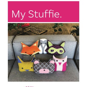 May include: A set of six plush animal toys, including a fox, penguin, raccoon, cat, bear, and owl, arranged on a gray couch. The toys are all handmade and feature bright colors and fun patterns. The text "My Stuffie." is displayed at the top of the image. The logos for "mary make & do" and "OWL & DRUM Sew Very Modern" are displayed at the bottom of the image.