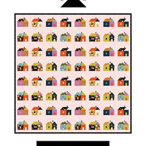 May include: A colourful quilt featuring a repeating pattern of small houses in various colours. The quilt is 178 cm x 183 cm and has a pink background. The text "Little House Quilt" is displayed at the bottom.