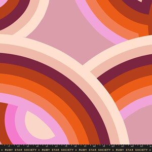 May include: A fabric with a retro design. It features layered, curved bands in shades of pink, orange, and burgundy against a light pink background, creating a rainbow effect. The text "RUBY STAR SOCIETY" is at the bottom.