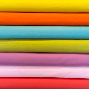May include: A stack of fabric swatches in various colors, including yellow, orange, turquoise, green, purple, pink, and red.