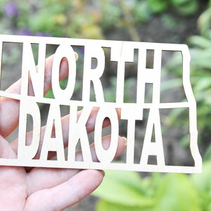 Inscrição do estado de Dakota do Norte - Corte a laser - branco inacabado - 5,1 polegadas - Texto em forma de mapa de Dakota do Norte