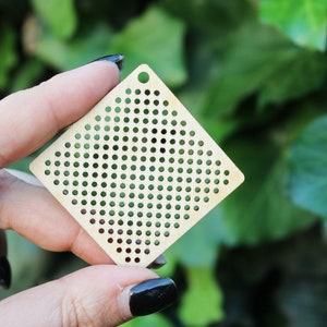 May include: A square piece of wood with a grid of small holes, perfect for crafting projects.