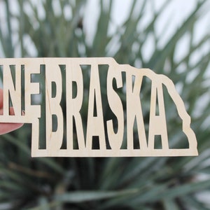 Inscrição do estado de Nebraska - Corte a laser - branco inacabado - 5,6 polegadas - Texto em forma de mapa de Nebraska
