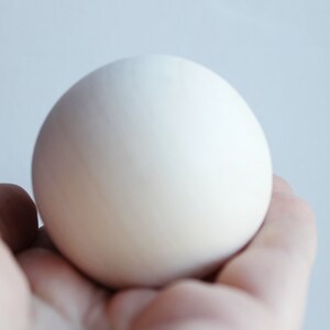 May include: A white egg held in a hand.