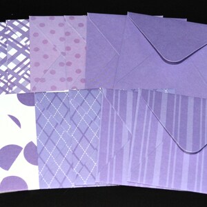 May include: A collection of paper envelopes in various shades of purple and lavender. The set includes designs featuring white and purple plaid patterns, purple polka dots, solid purple, white with purple semi-circles, and purple vertical stripes.