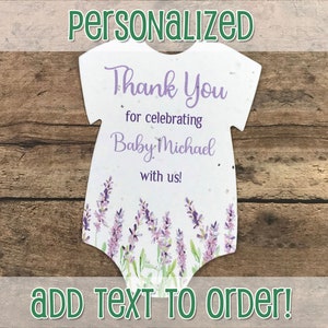 K&ouml;nnte beinhalten: Wei&szlig;e Papierkarte in Form eines Baby-Bodys mit Lavendelbl&uuml;ten und dem Text "Vielen Dank, dass Sie Baby Michael mit uns feiern!"  Text zum Bestellen hinzuf&uuml;gen!
