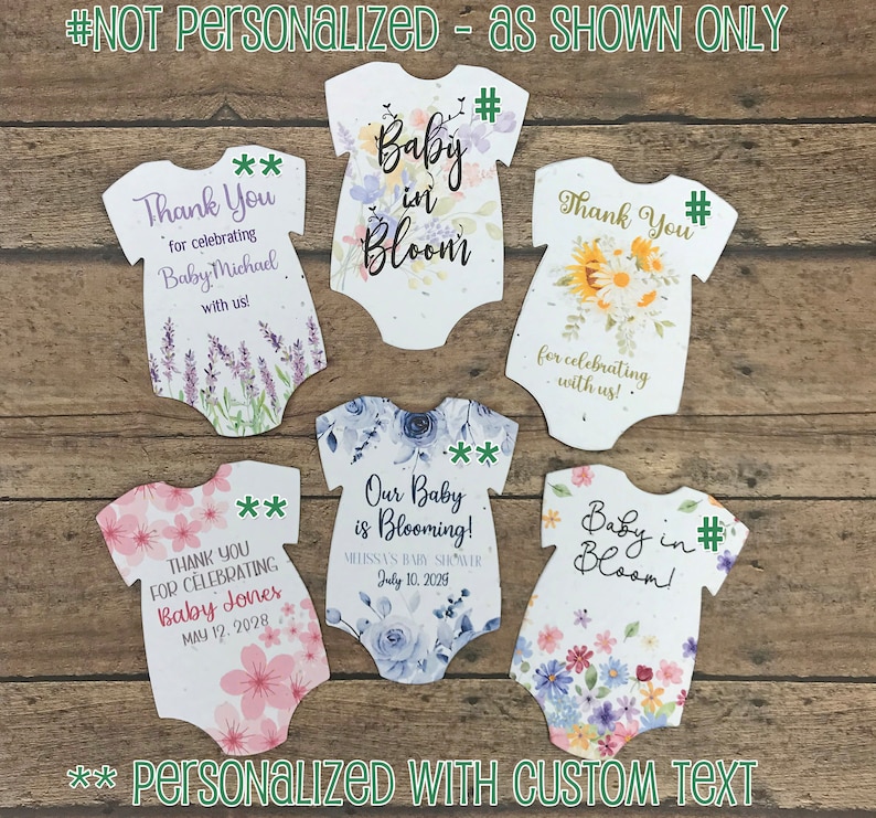 K&ouml;nnte beinhalten: F&uuml;nf wei&szlig;e Baby-Strampler-f&ouml;rmige Dankeskarten mit Blumendesigns. Der Text auf den Karten lautet "Vielen Dank f&uuml;r die Feier von Baby Michael mit uns!" "Vielen Dank f&uuml;r die Feier mit uns!" "Vielen Dank f&uuml;r die Feier von Baby Jones 12. Mai 2028" "Unser Baby bl&uuml;ht! Baby Shower von Melissa 10. Juli 2029" und "Baby in Bloom!"