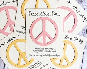 May include: Peace, love, and party! A set of four seed paper cards with a peace sign design. The cards are pink and yellow and have the text "Peace. Love. Party" printed on them. Each card has a message thanking the recipient for celebrating their birthday and includes the text "Plant this peace sign and wildflowers will grow."