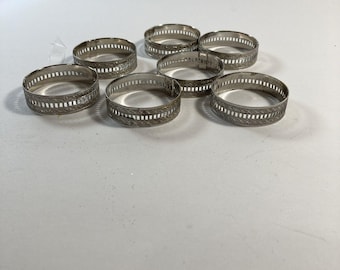 Juego de 7 servilleteros vintage de plata chapada con diseño floral grabado.