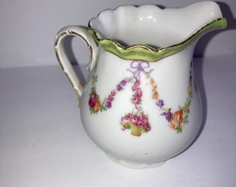 Jarra de cerámica vintage con diseño floral y detalles verdes y dorados