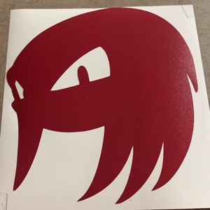 May include: A red silhouette of a cartoon character's head with a single eye and spiky hair.