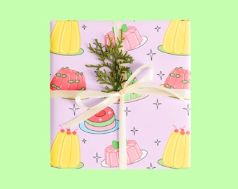 Op de afbeelding: Een paarse cadeaudoos met een wit lint en een takje groen. De doos is ingepakt in papier met een herhalend patroon van kleurrijke cartoon-gelei-desserts.