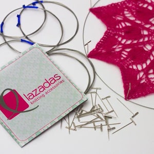 Puede incluir: Un juego de agujas de tejer circulares, un encaje de ganchillo rosa y un paquete de accesorios de tejido etiquetado como "Lazadas knitting accessories".