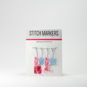 Puede incluir: Un conjunto de cinco marcadores de punto para tejer o hacer ganchillo. Los marcadores son de color rosa y azul y tienen la palabra "Lazadas" en ellos. El embalaje dice "Stitch Markers" y "never lose a stitch".