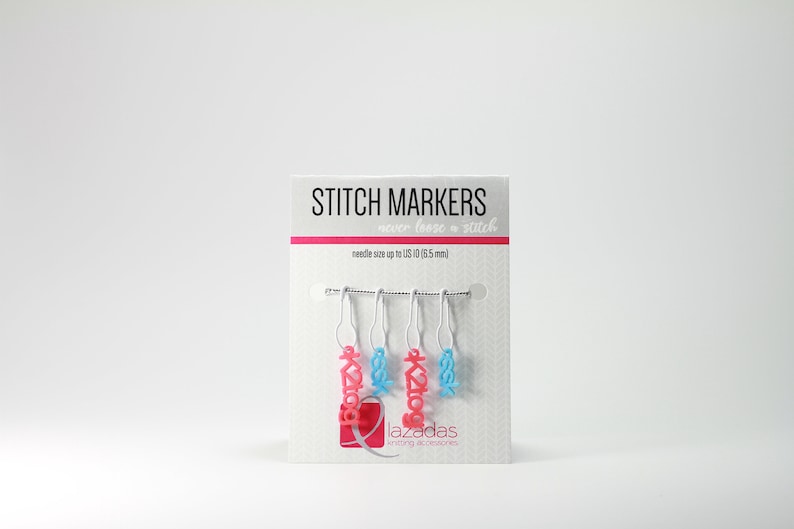 May include: A set of five stitch markers for knitting or crocheting. The markers are pink and blue and have the word "Lazadas" on them. The packaging says "Stitch Markers" and "never lose a stitch".