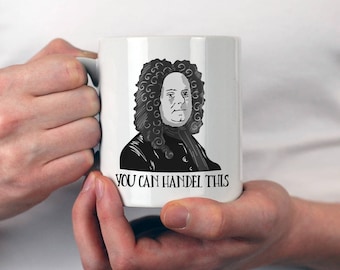 May include: White ceramic mug with a black and white illustration of George Frideric Handel. The mug has the text "You Can Handel This" printed on the bottom.