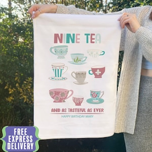 Puede incluir: Paño de cocina blanco con las palabras "NINE TEA" en rosa y verde azulado. El paño presenta nueve tazas de té en varios diseños y colores. El texto "AND AS TASTEFUL AS EVER" y "HAPPY BIRTHDAY MARY" también está impreso.